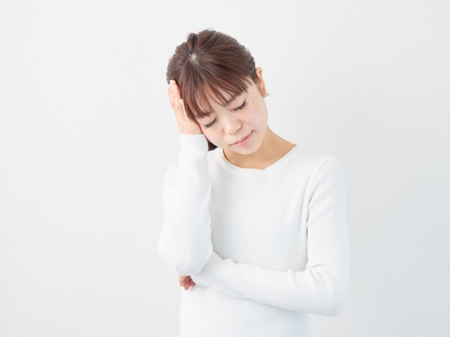 頭を抱えて悩む女性