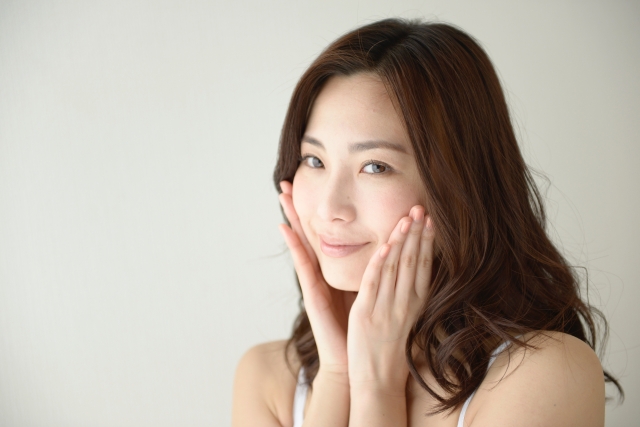 頬に手を当てて微笑んでいる女性