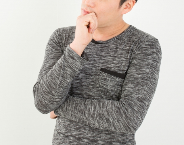顎に手を当てて考え込む男性