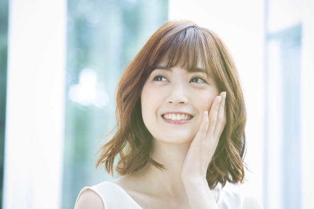 女性が顔を触っている